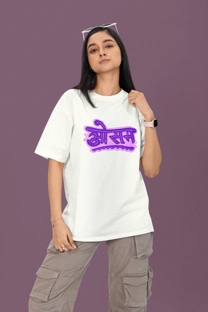 First front view of a female model wearing a off-white colored oversized graphic t-shirt featuring the word "awesome" in a Hindi script.