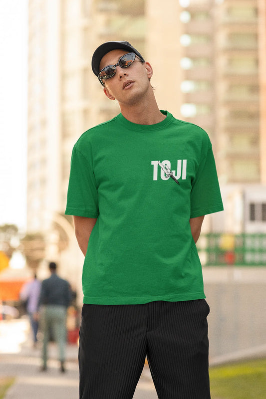 First front view of a male model wearing a forest green oversized t-shirt featuring Toji Fushiguro from the Jujutsu Kaisen anime.