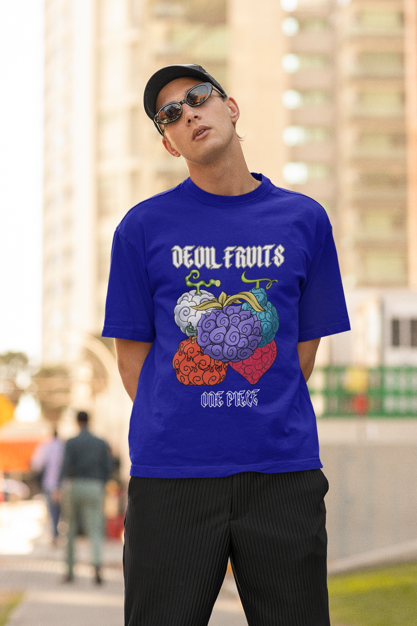 First front view of a male model wearing a royal blue oversized t-shirt featuring a design of a Devil Fruit from the One Piece anime.