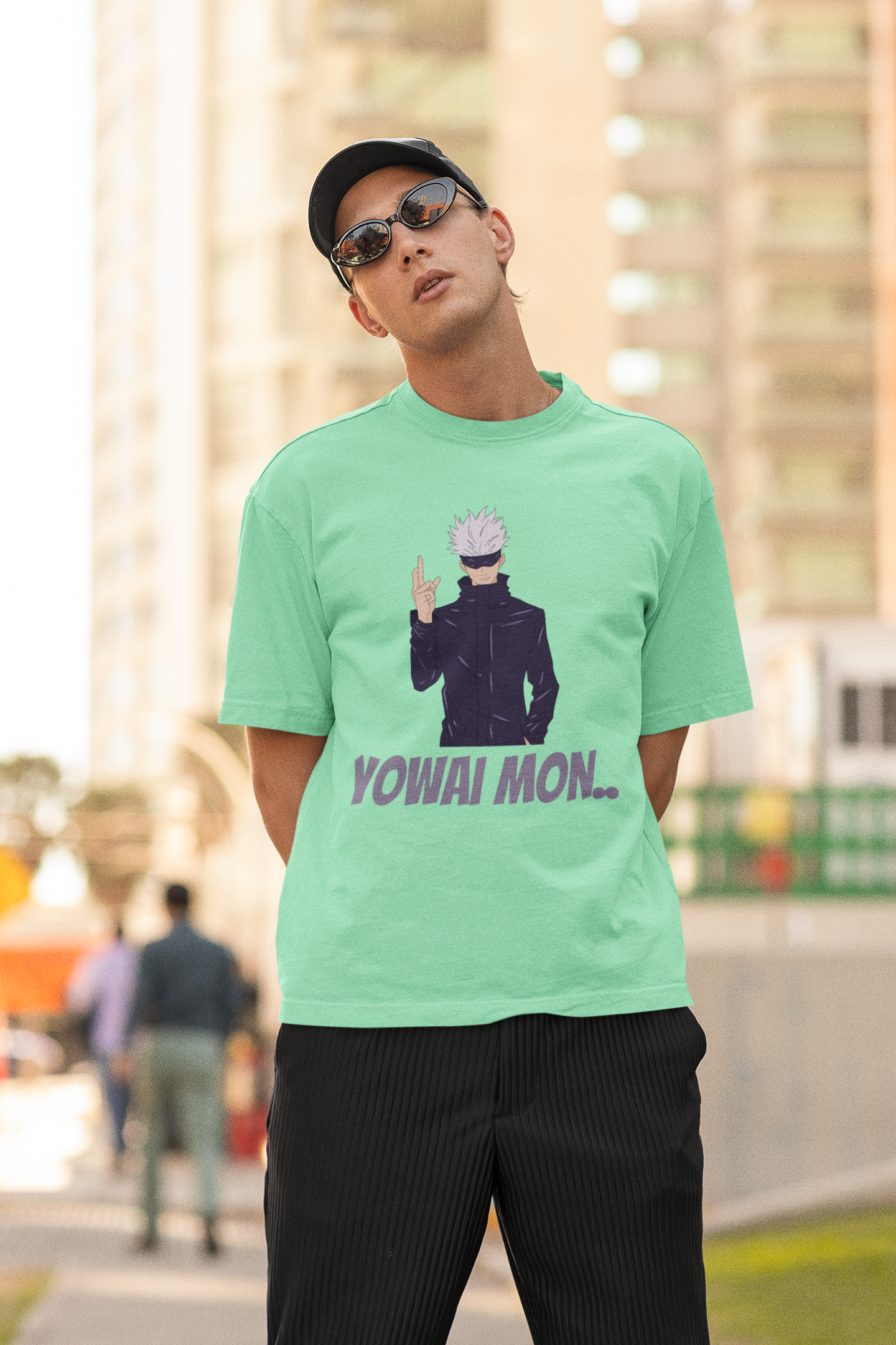 3rd front view of a male model wearing a mint green oversized t-shirt featuring Gojo Satoru with his fingers crossed and the text "Yowai Mon."