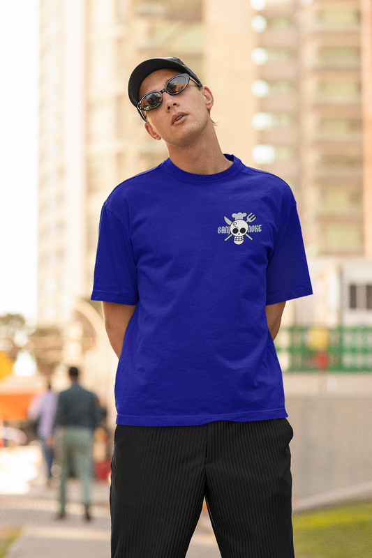 First front view of a male model wearing a royal blue oversized t-shirt featuring Sanji's skull and crossbones logo and the text "The Cook and Black Leg."