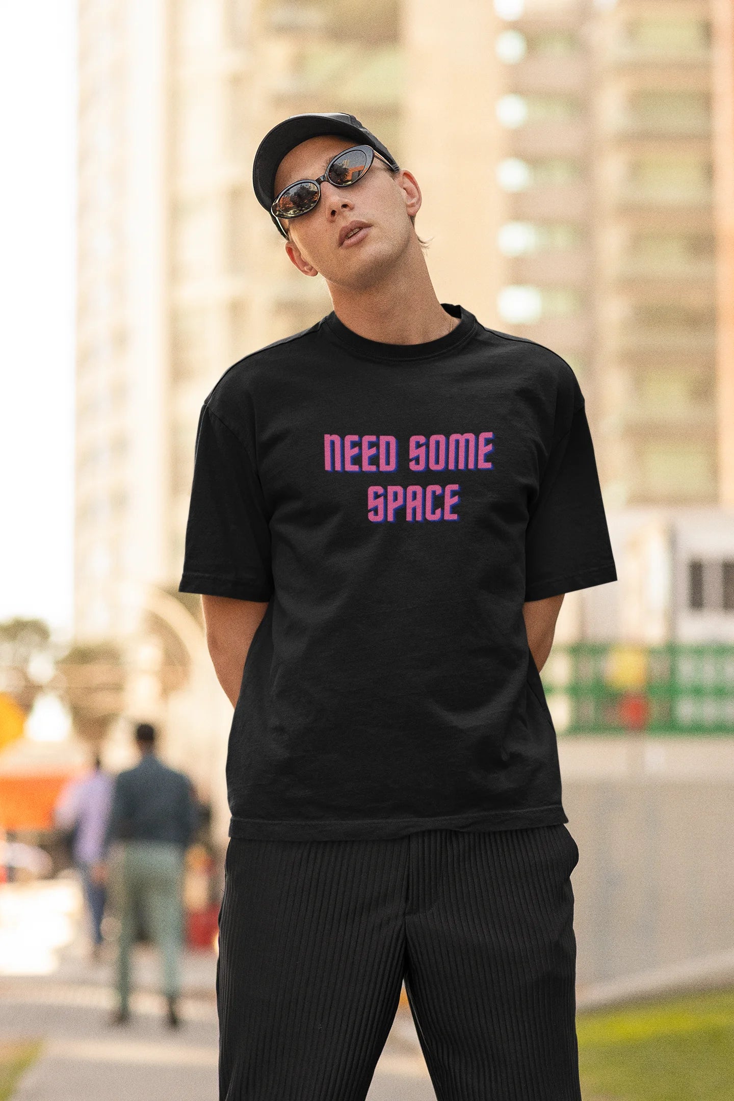 Second front view image of a male model wearing a black oversized t-shirt with a bold graphic that reads "Need Some Space" on the front. The design incorporates subtle hints of the Milky Way galaxy and the solar system on the back.