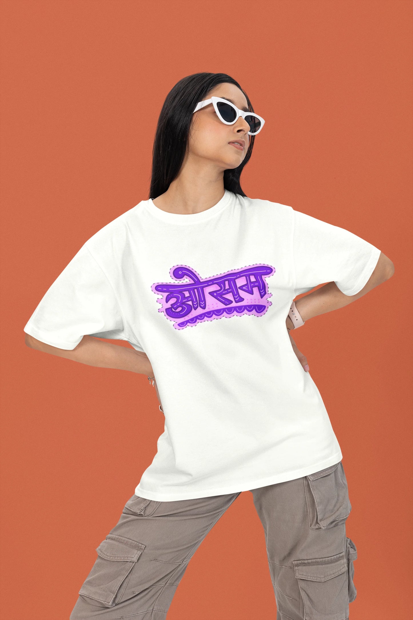 2nd front view of a female model wearing a off-white colored oversized graphic t-shirt featuring the word "awesome" in a Hindi script.