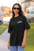 Front view  of woman wearing black Oversize T-shirt featuring Swiftie design, taylor's version