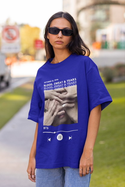 Front view of a female model wearing a royal blue oversized t-shirt featuring a design inspired by BTS's music video "Blood, Sweat & Tears." Ideal for BTS fans (ARMY) who want to celebrate this iconic era.