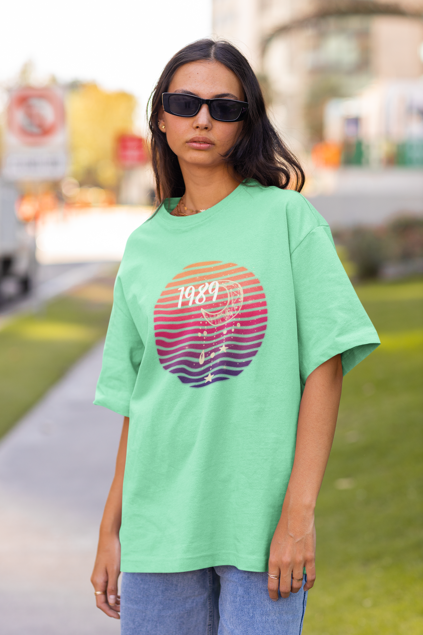 Front view of woman wearing mint green coloured Oversize T-shirt featuring Taylor Swift 1989 design, Taylor's Version, and Eras Tour Merch