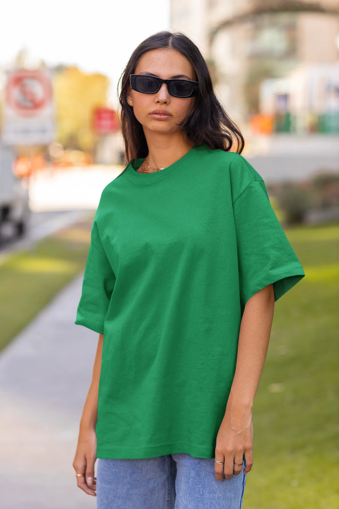 Front view of female model wearing a forest green oversized t-shirt featuring a captivating "moonlight" design with subtle elements of the Milky Way galaxy, planets, and the soft glow of the moon.