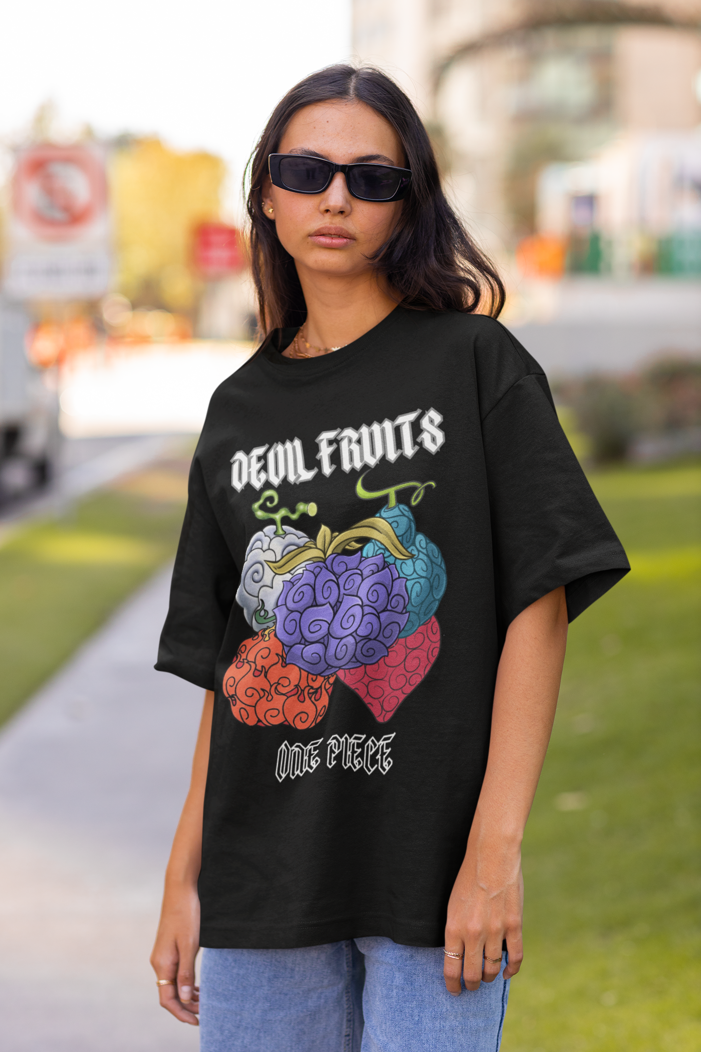 2nd front view of a female model wearing a black oversized t-shirt featuring a design of a Devil Fruit from the One Piece anime.