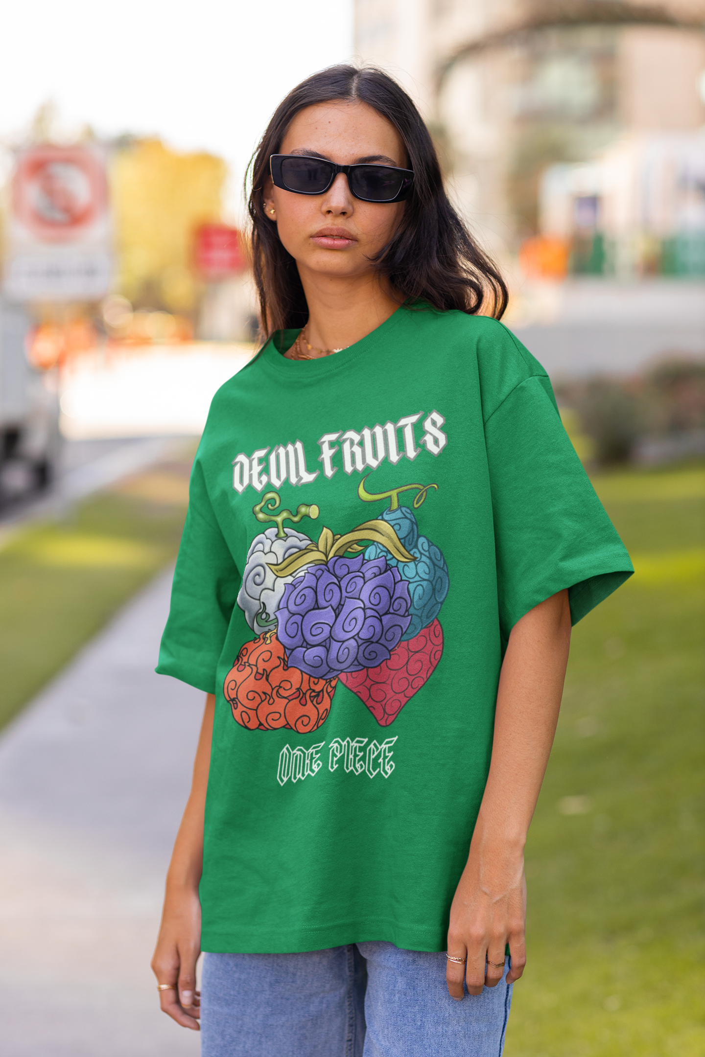 3rd front view of a female model wearing a forest green oversized t-shirt featuring a design of a Devil Fruit from the One Piece anime.