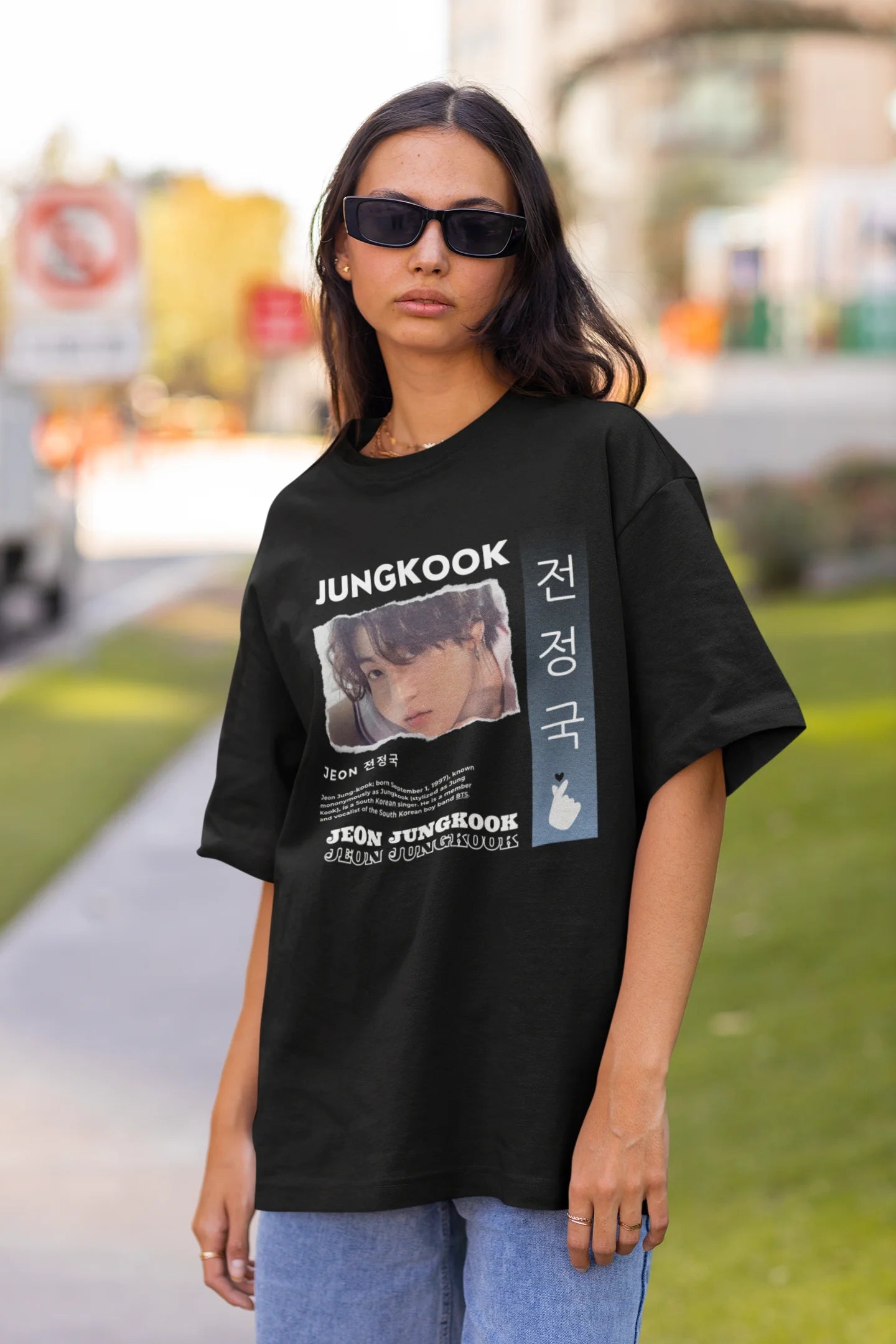 Front view of a female model wearing a black oversized t-shirt featuring a vibrant design inspired by BTS member Jungkook. Ideal for fans of BTS and K-Pop music in general.