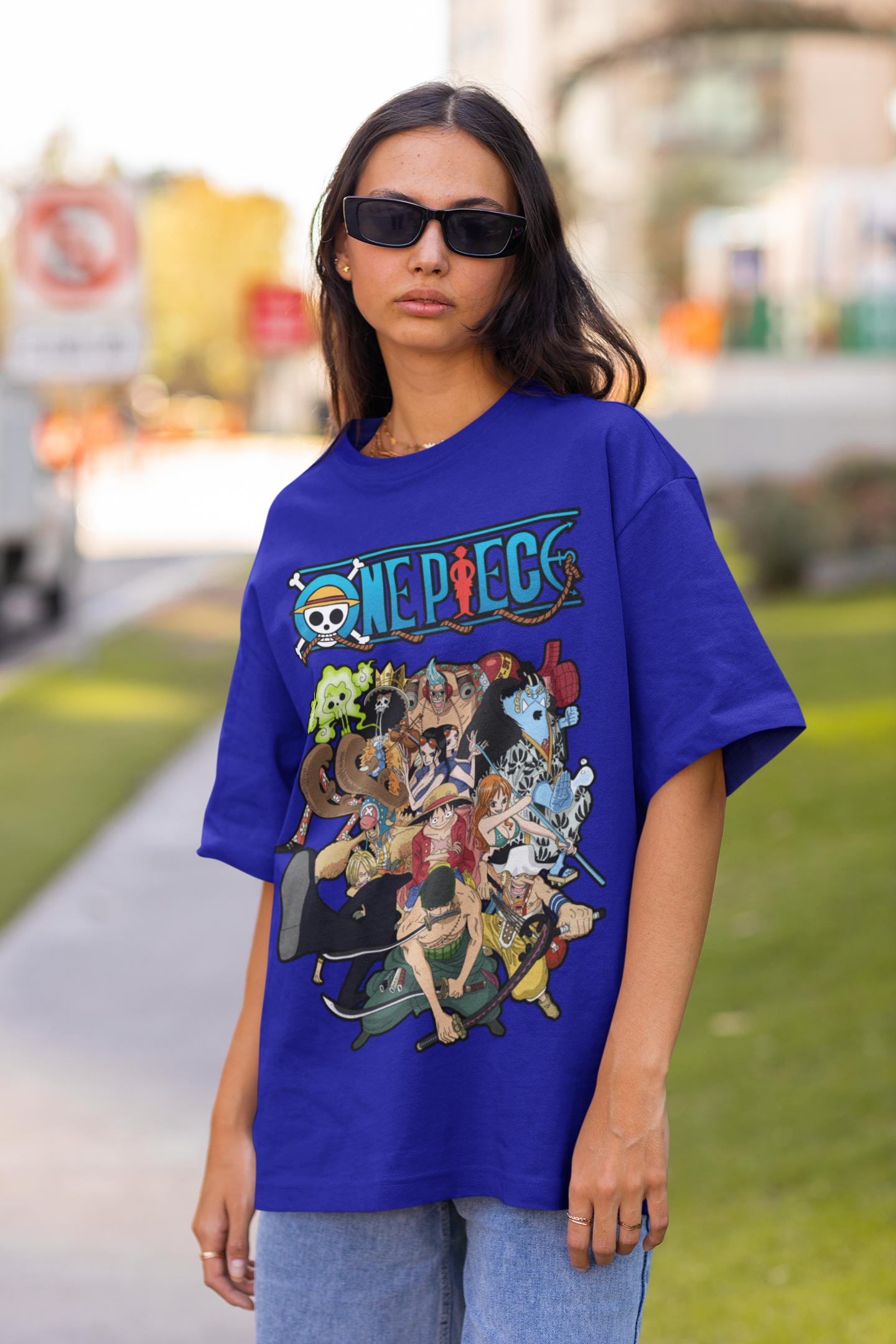 3rd front view of a female model wearing a royal blue oversized t-shirt featuring the entire Straw Hat Crew from the One Piece anime.