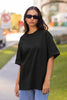 Front view of a female model wearing a black oversized t-shirt featuring a design inspired by the cosmos and galaxies 