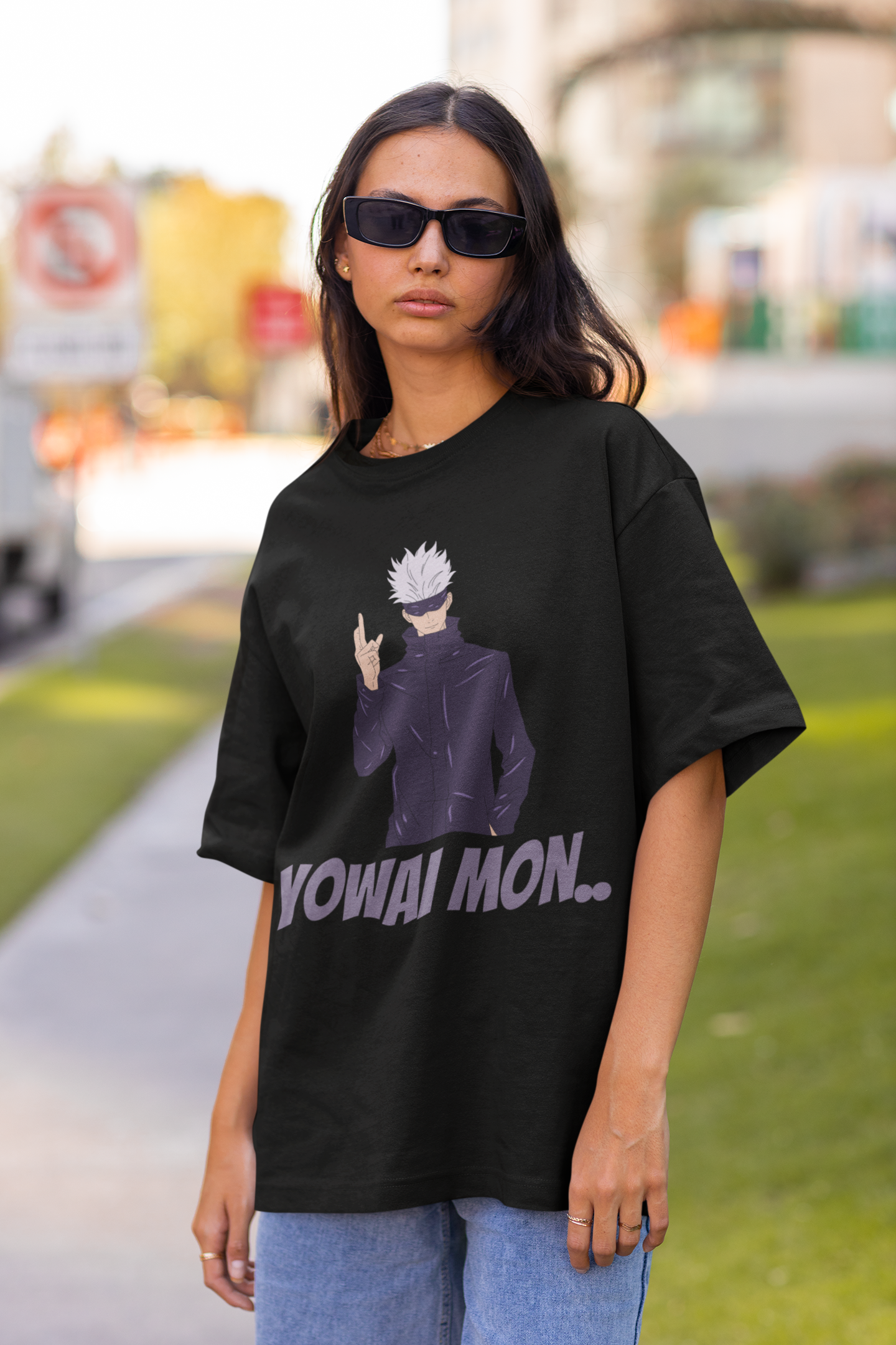 3rd front view of a female model wearing a black oversized t-shirt featuring Gojo Satoru with his fingers crossed and the text "Yowai Mon."