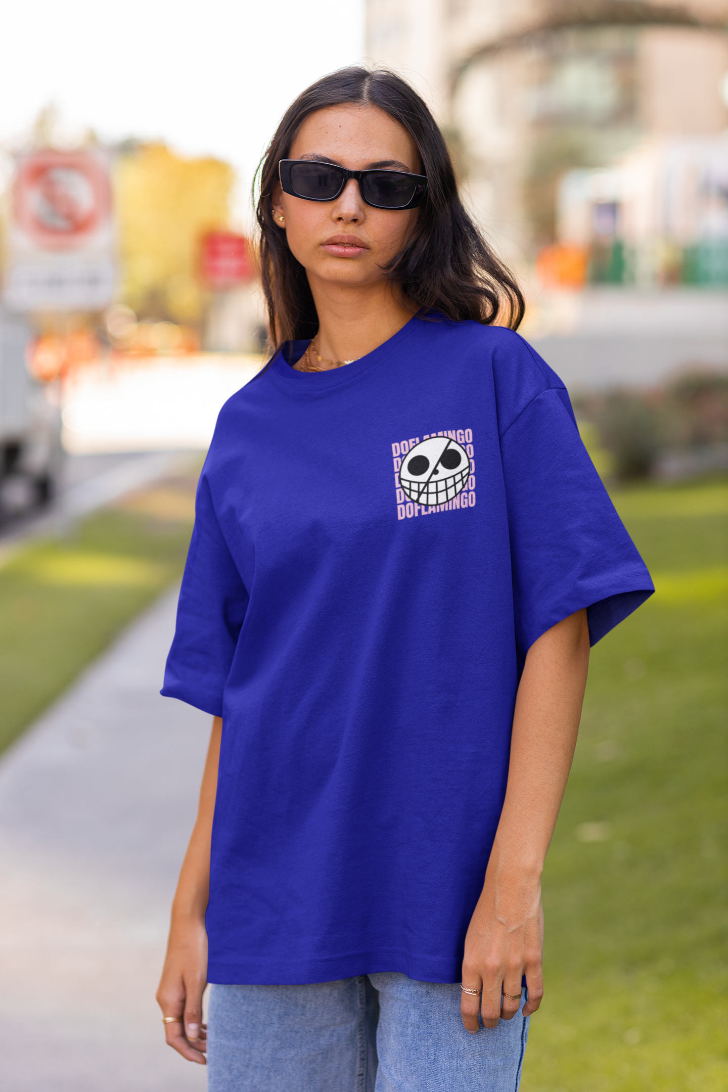 2nd front view of a female model wearing a royal blue oversized t-shirt featuring Donquixote Doflamingo from the One Piece anime.