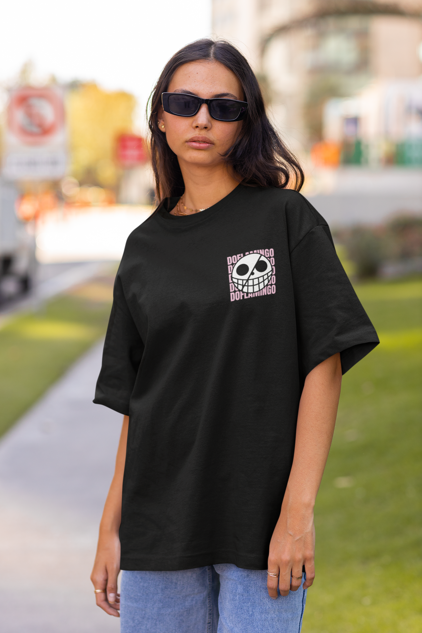 2nd front view of a female model wearing a black oversized t-shirt featuring Donquixote Doflamingo from the One Piece anime.