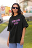 Front view of a female model wearing a black oversized t-shirt with a bold graphic that reads 