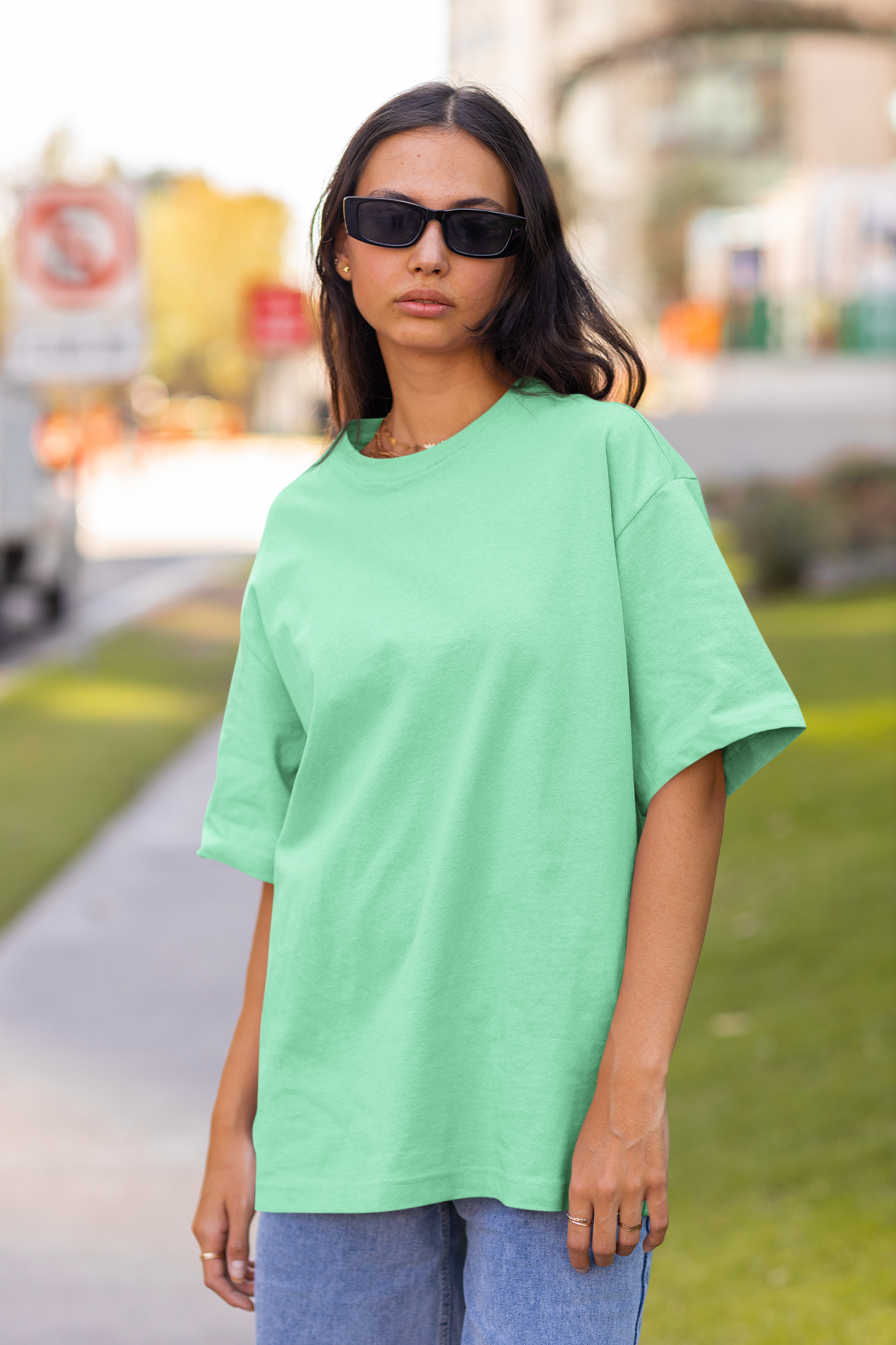 2nd front view of a female model wearing a mint green oversized t-shirt featuring Crocodile, the Desiccation Master, from the One Piece anime.
