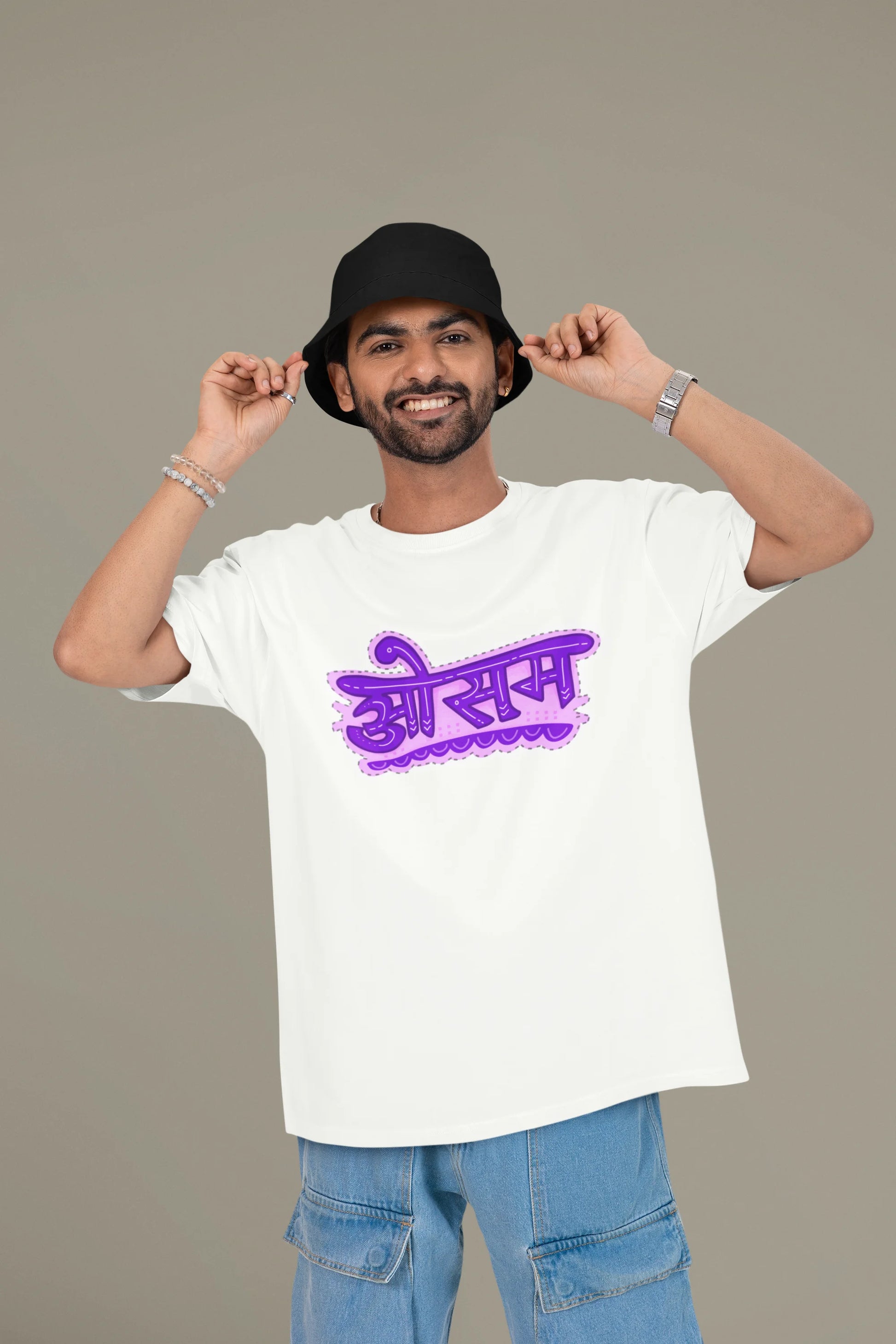 First front view of a male model wearing a off-white colored oversized graphic t-shirt featuring the word "awesome" in a Hindi script.