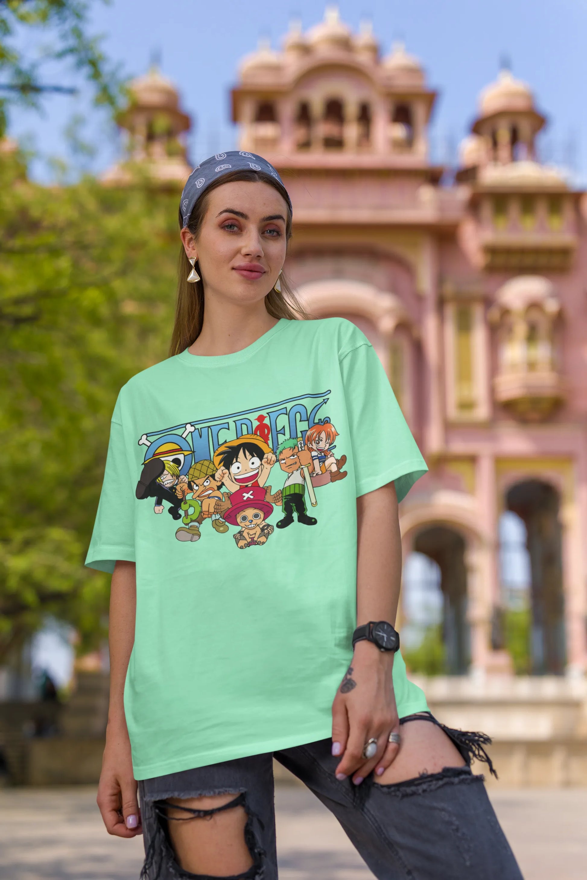 First front view of a female model wearing an mint green oversized t-shirt featuring chibi versions of the Straw Hat Crew from the One Piece anime.