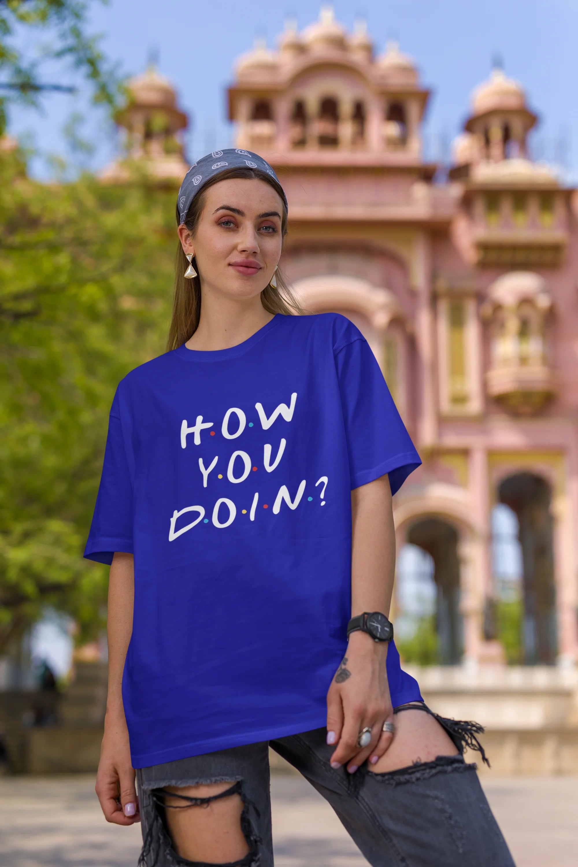 First image of female model wearing blue oversized t-shirt with F.R.I.E.N.D.S series inspired designs, embodying Joey's famous catchphrase 'How You Doin'?