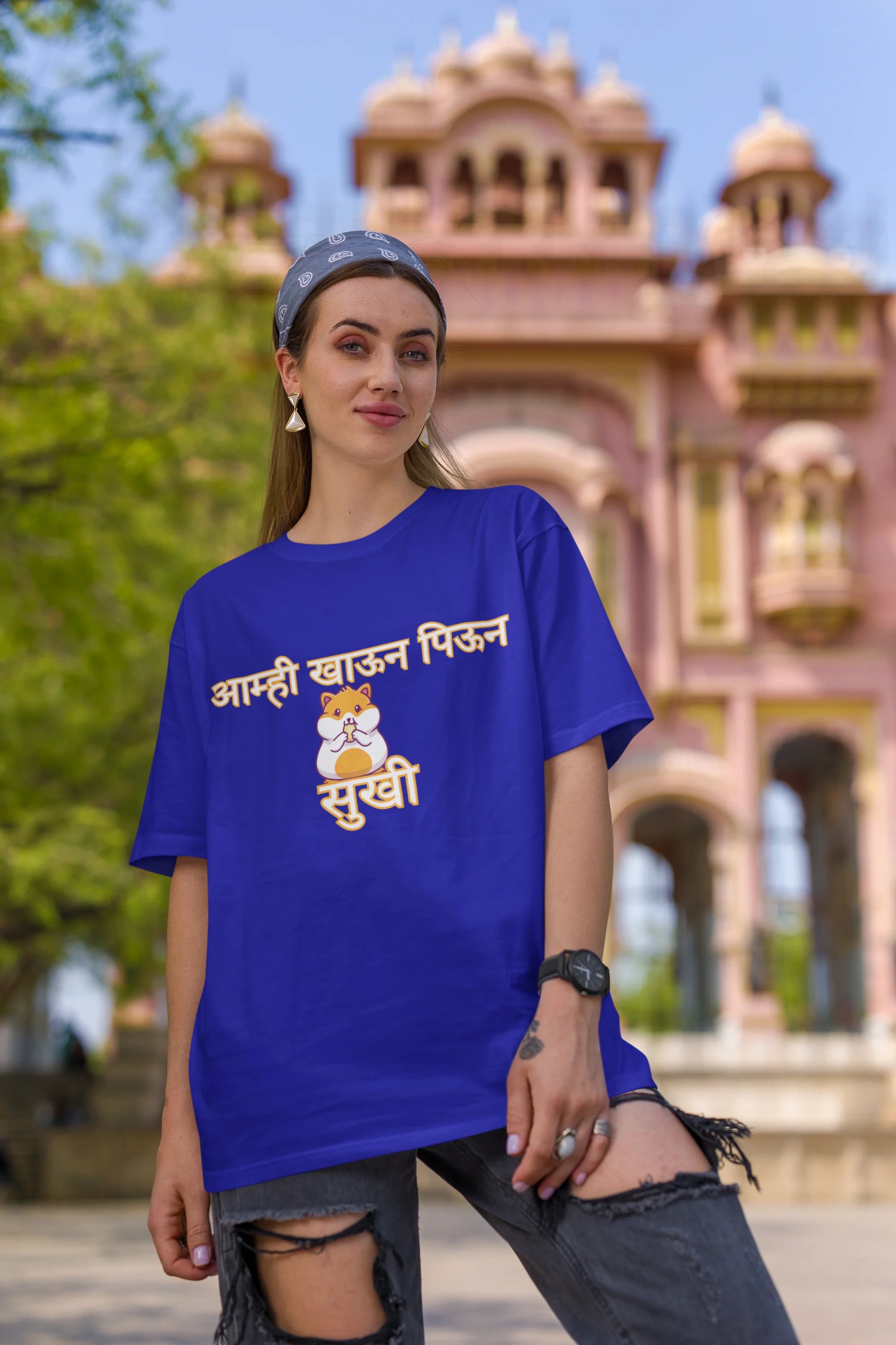 Third front view of female model wearing a royal blue oversized t-shirt featuring a design inspired by the Marathi dish "Sukhi," a dry lentil curry. Perfect for fans of Marathi culture, foodies, and anyone who loves a taste of home.