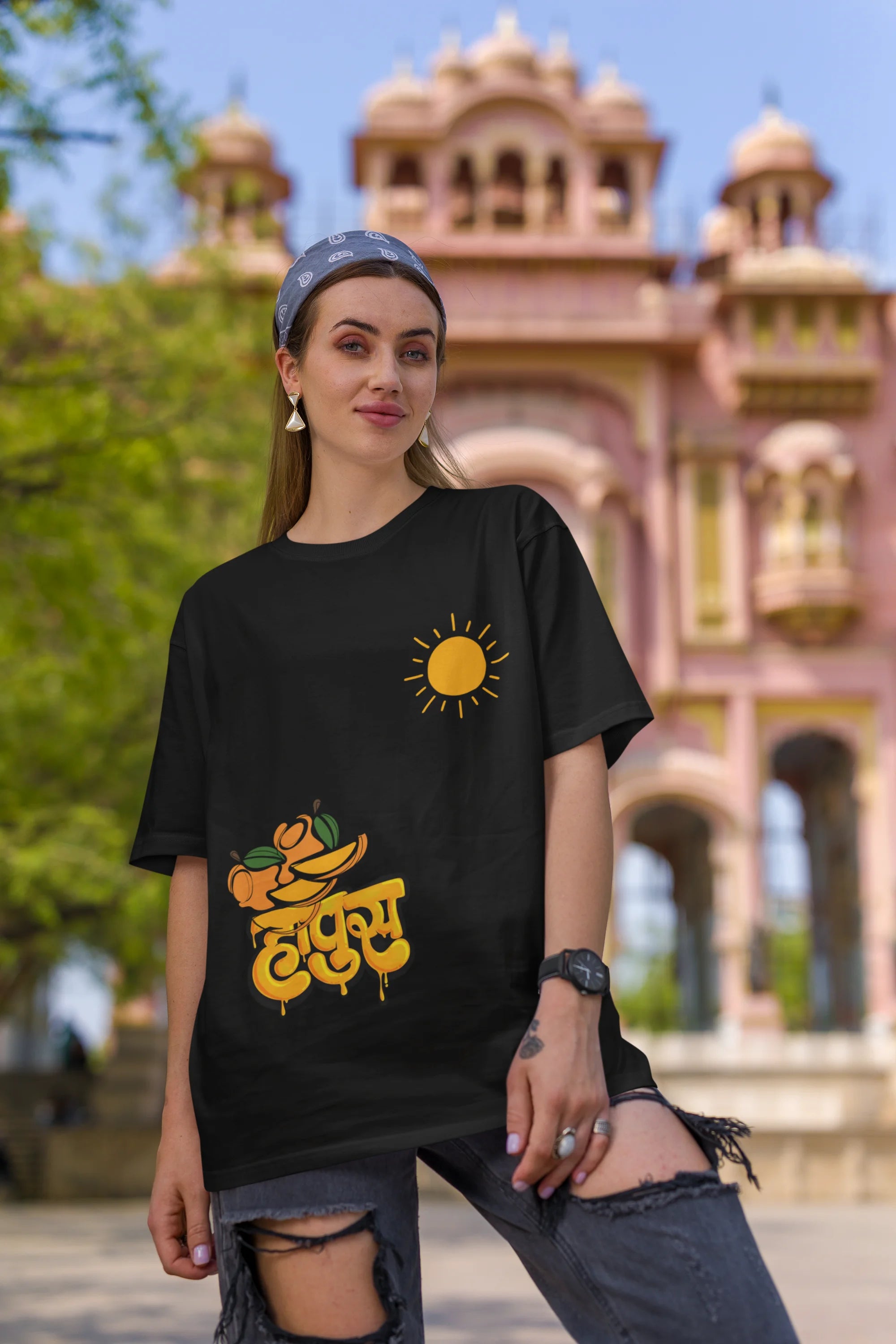 First front view of female model wearing an black oversized t-shirt featuring a design inspired by the Marathi word "Hapus," meaning Alphonso mango. Ideal for fans of Marathi culture, foodies, and anyone who loves the king of fruits.