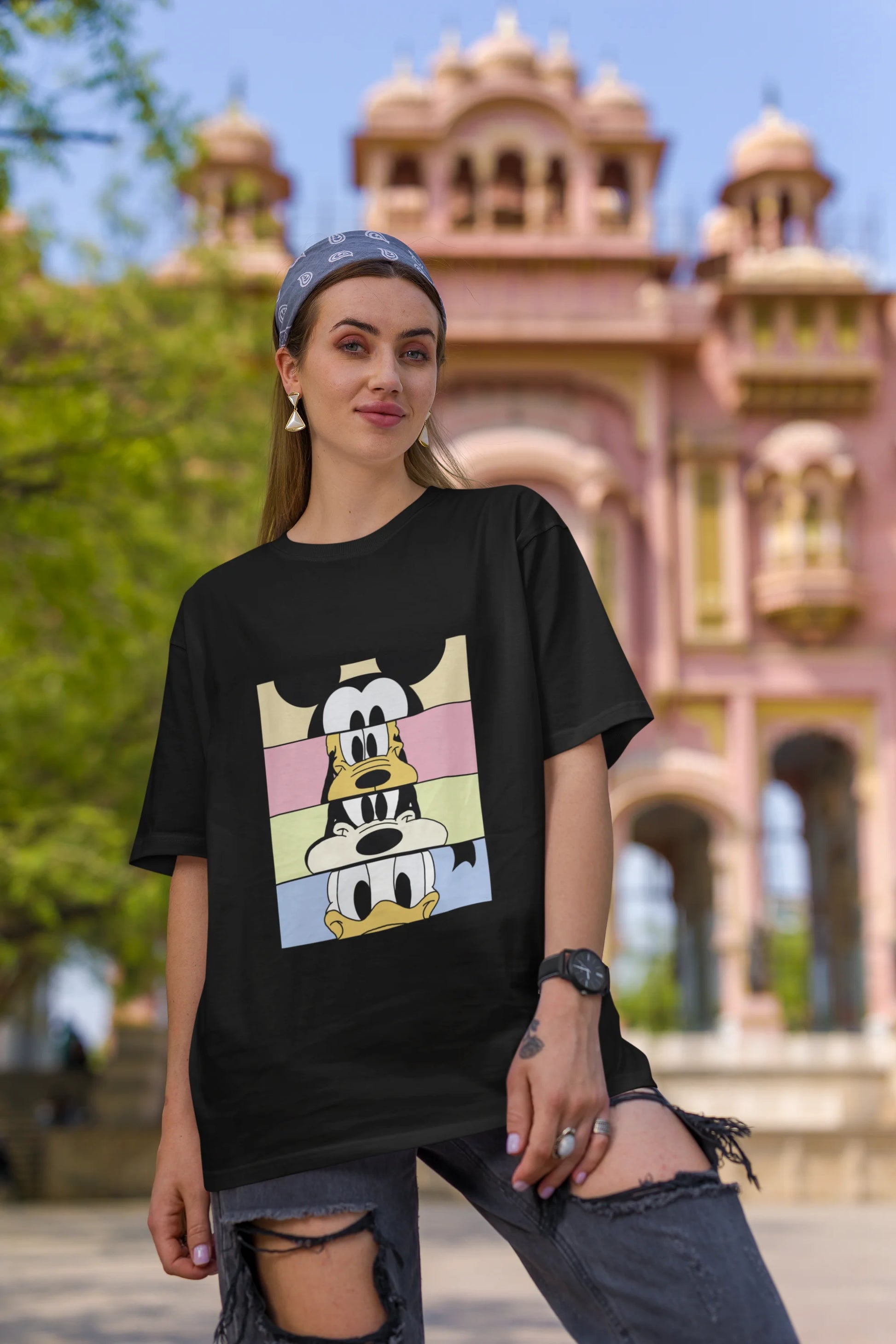 Second image of female Model showcasing black oversized t-shirt inspired by Mickey Mouse Clubhouse characters: Mickey Mouse, Donald Duck, Goofy, and Minnie Mouse