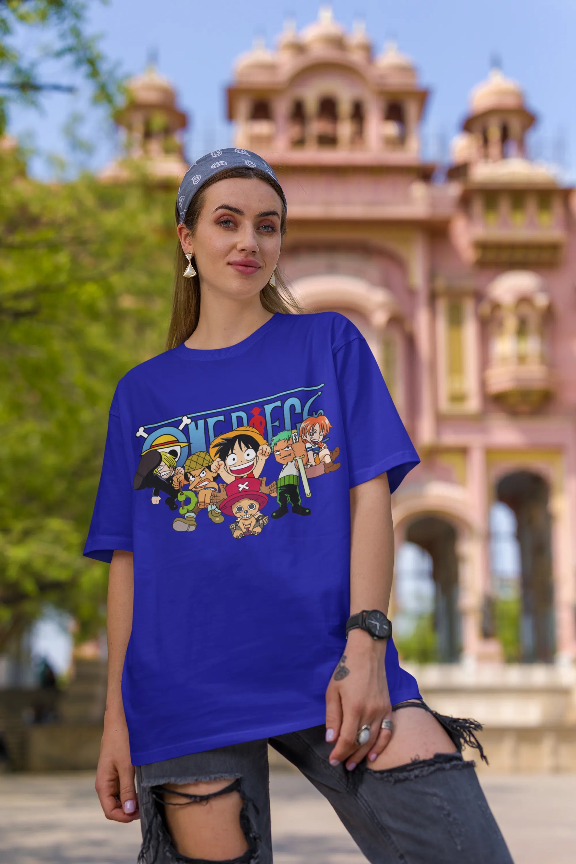 First front view of a female model wearing a royal blue oversized t-shirt featuring chibi versions of the Straw Hat Crew from the One Piece anime.