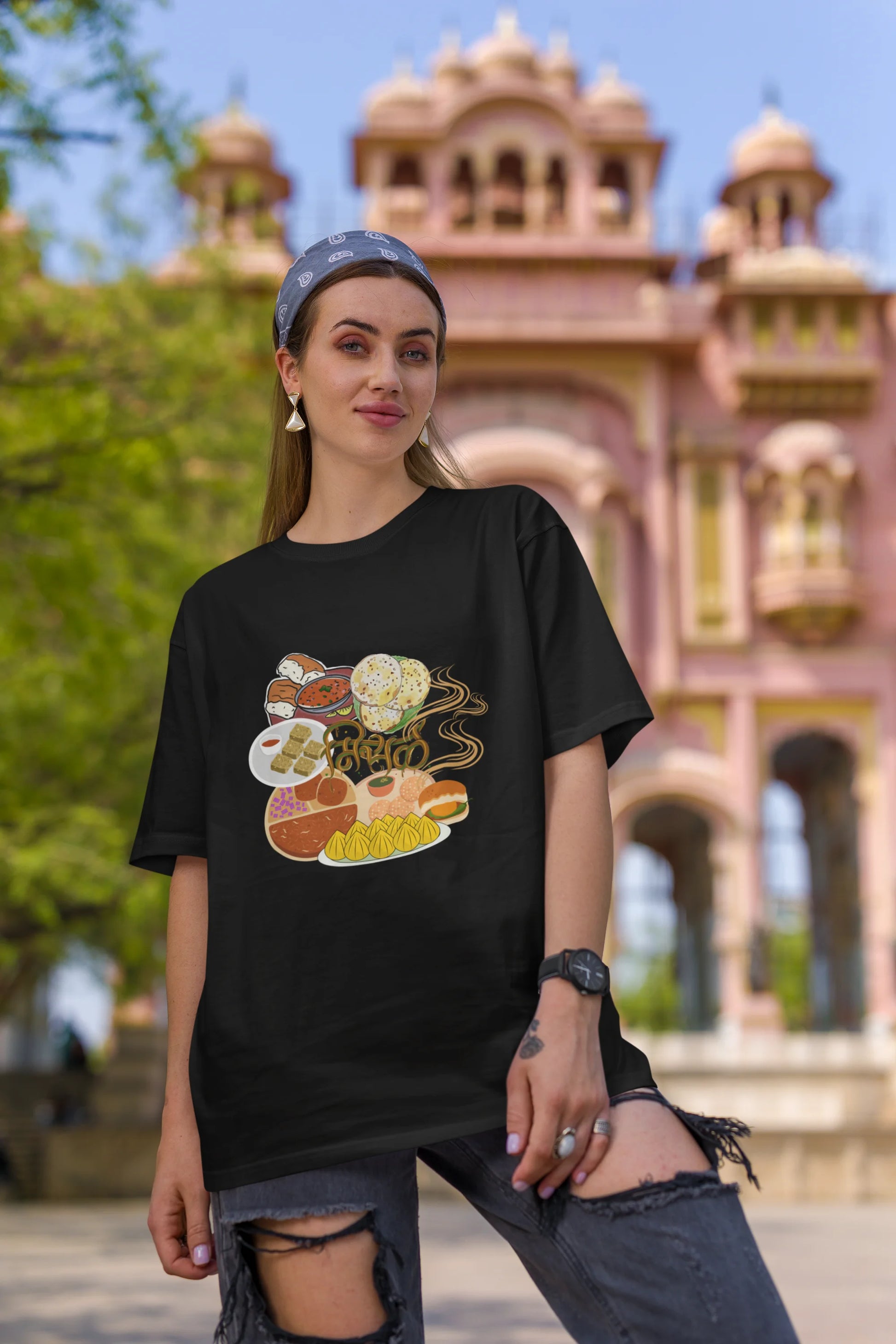 First front view of female model wearing an black oversized t-shirt featuring a design inspired by the Marathi dish Misal Pav. Ideal for fans of Marathi culture, foodies, and anyone who loves a flavorful meal.