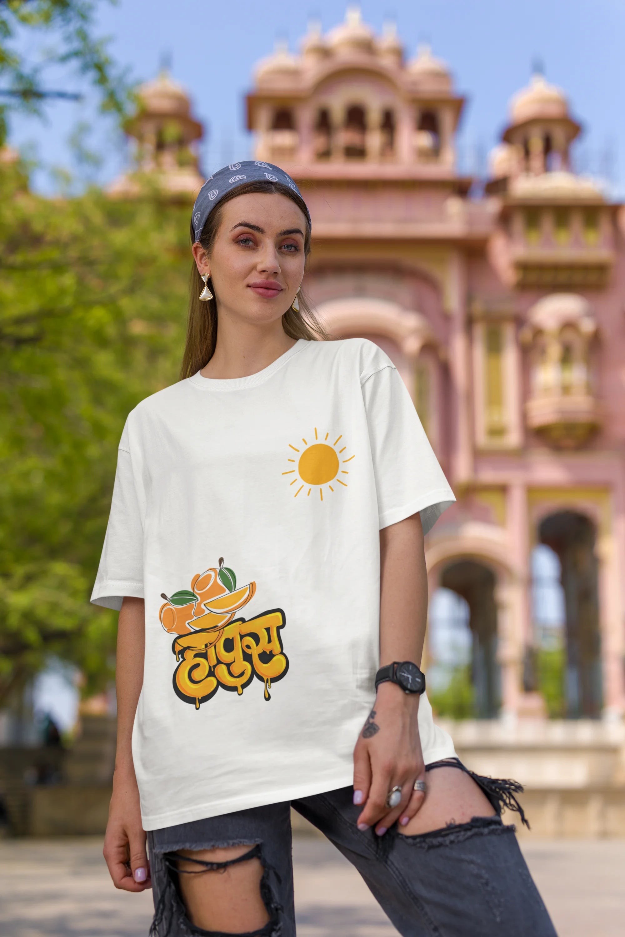 First front view of female model wearing an off-white oversized t-shirt featuring a design inspired by the Marathi word "Hapus," meaning Alphonso mango. Ideal for fans of Marathi culture, foodies, and anyone who loves the king of fruits.