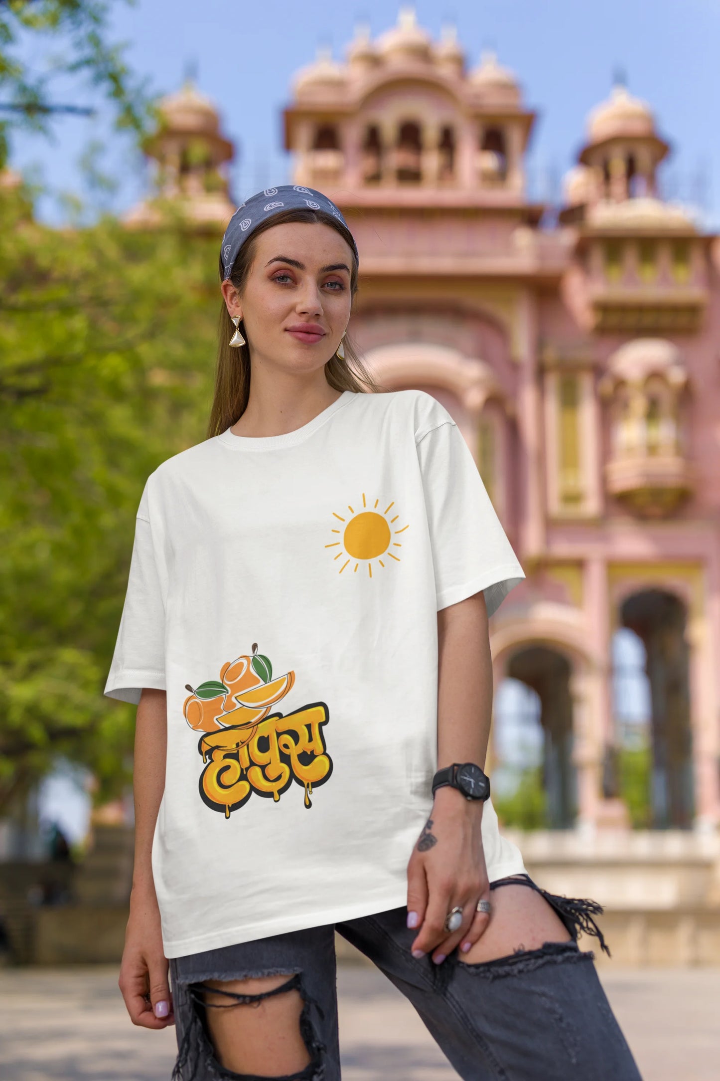 First front view of female model wearing an off-white oversized t-shirt featuring a design inspired by the Marathi word "Hapus," meaning Alphonso mango. Ideal for fans of Marathi culture, foodies, and anyone who loves the king of fruits.
