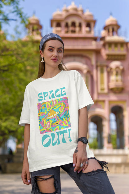 First image of female model wearing an off white oversized "Spaced Out" t-shirt featuring a vibrant color mashup design that evokes a sense of space exploration, playful aliens, and distant galaxies.