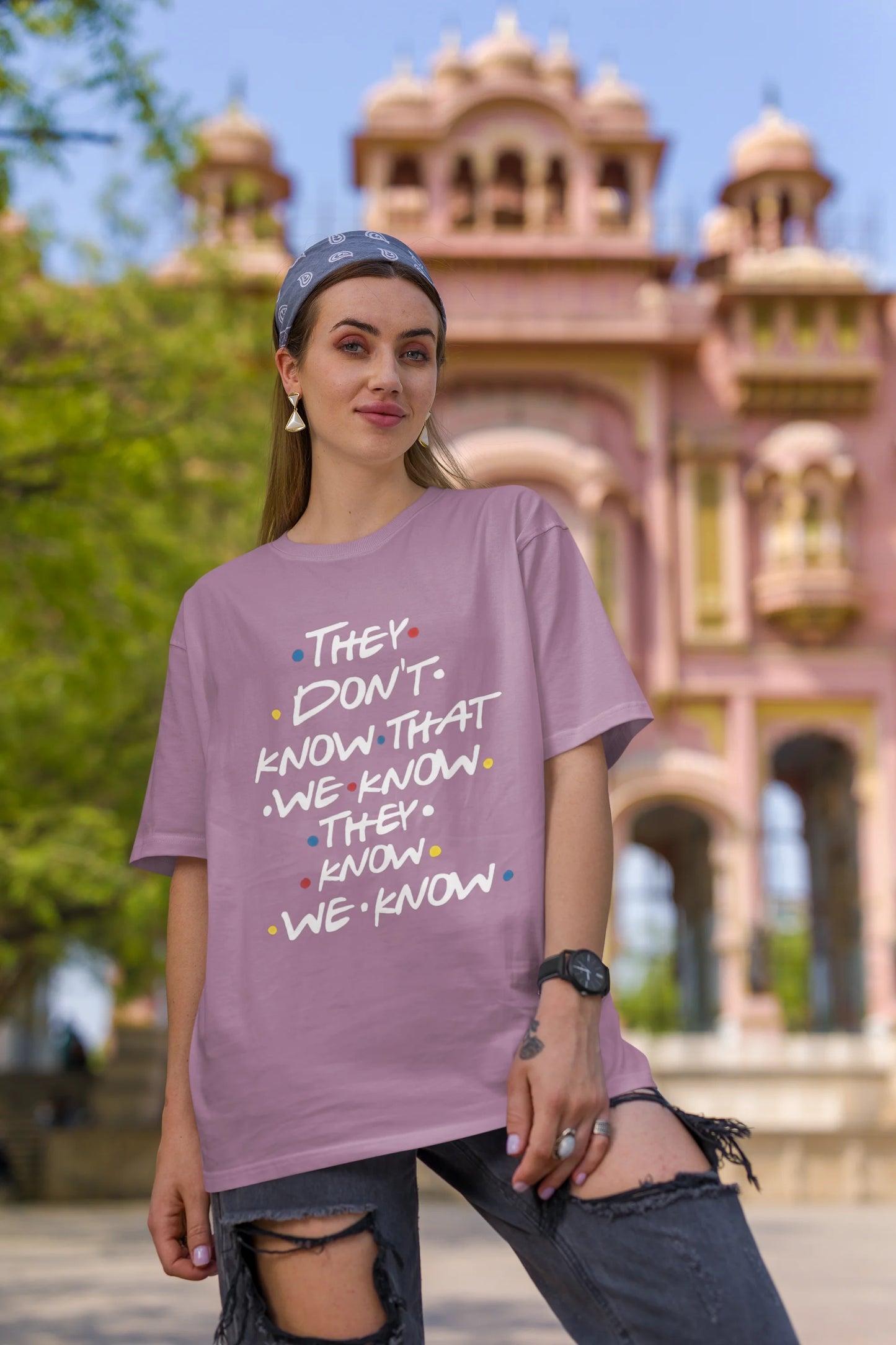 First image of female model wearing dirty purple oversized t-shirt with F.R.I.E.N.D.S series inspired designs, embodying Phoebe's unique humor with the quote 'They Know We Know'
