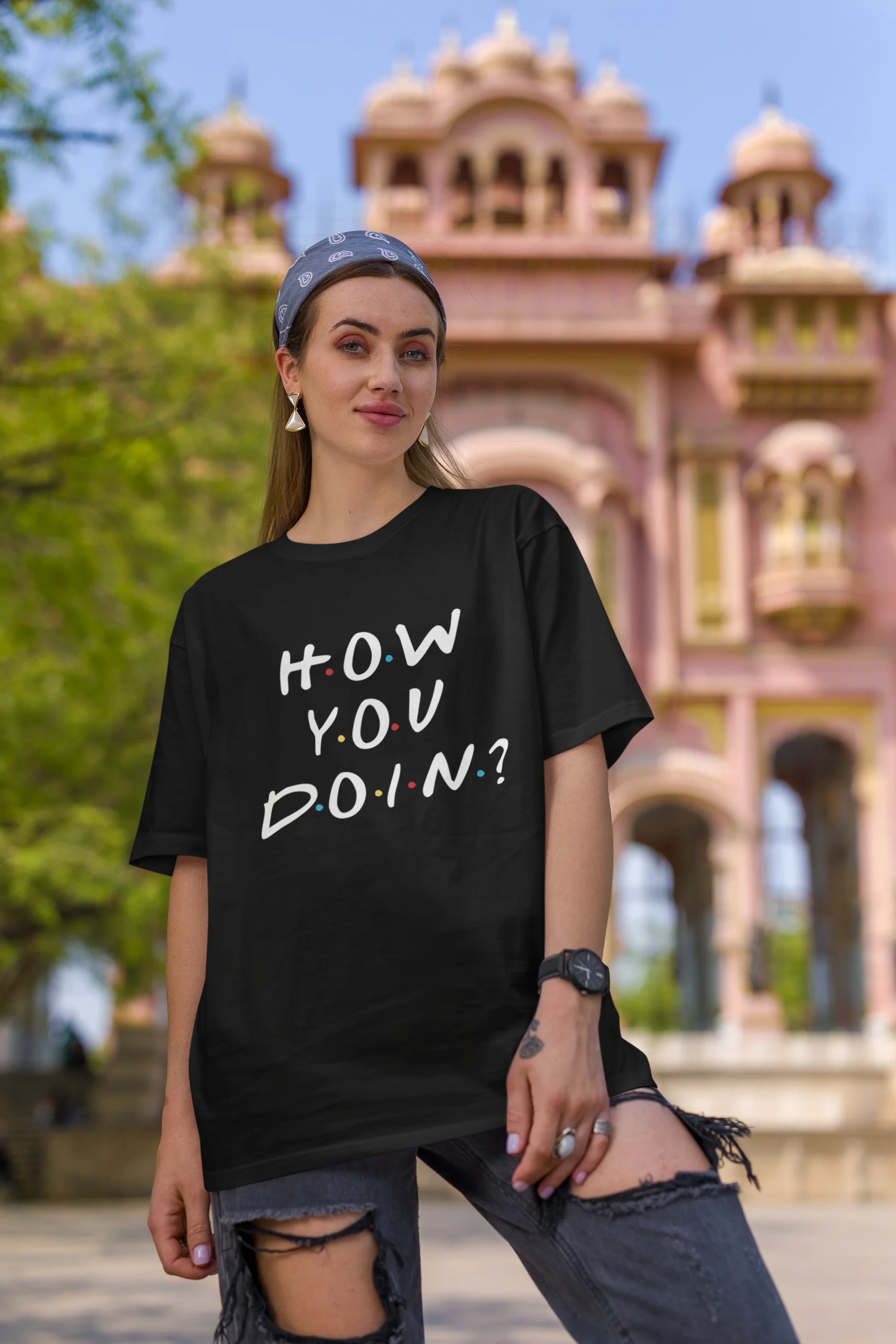 First image of female model wearing black oversized t-shirt with F.R.I.E.N.D.S series inspired designs, embodying Joey's famous catchphrase 'How You Doin'?