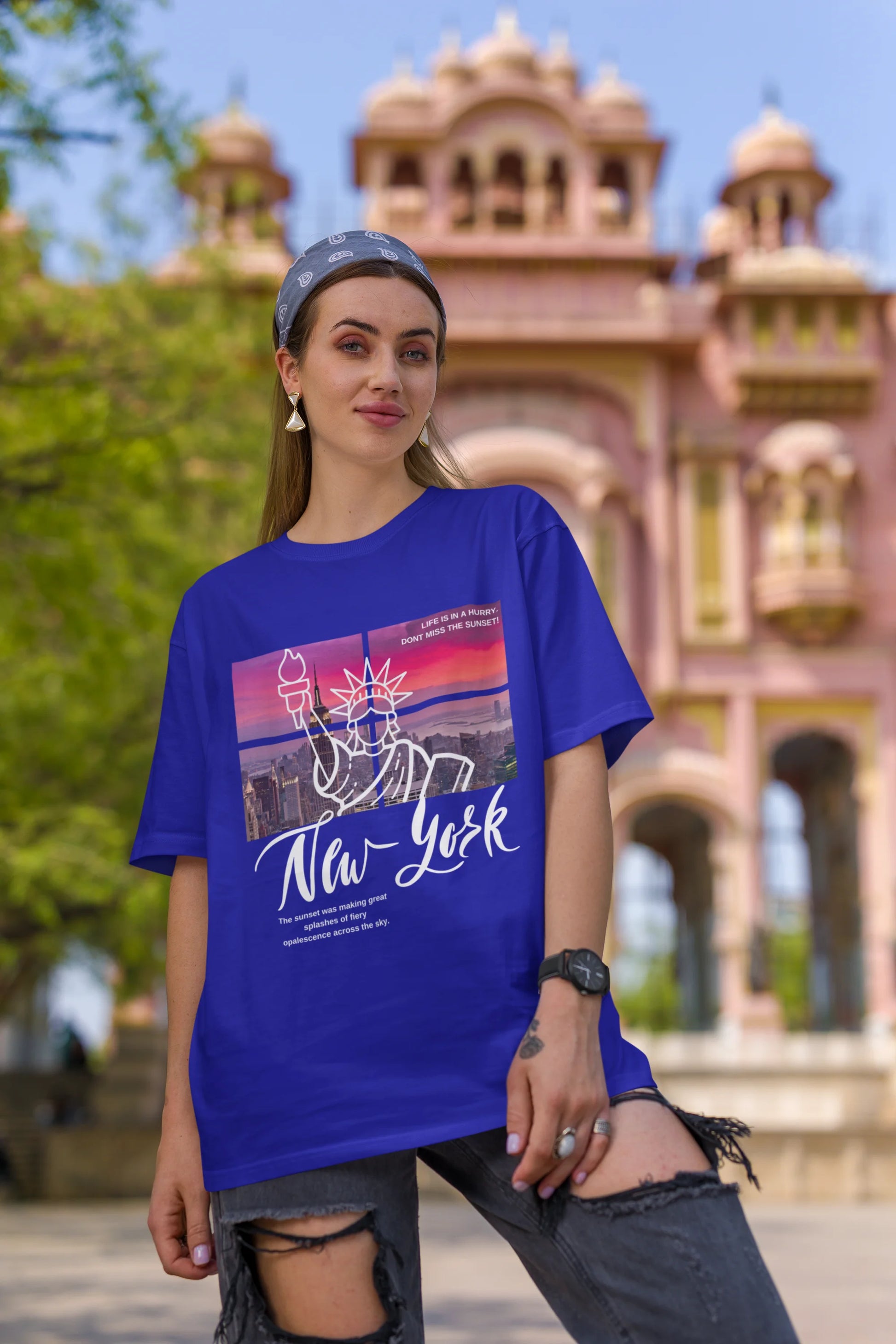 First front view of a female model wearing a royal blue oversized t-shirt with a New York City skyline design, offering a relaxed urban aesthetic.