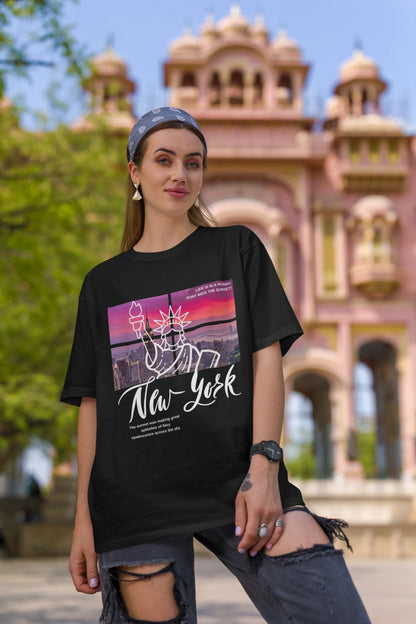 First front view of a female model wearing a black oversized t-shirt with a New York City skyline design, offering a relaxed urban aesthetic.
