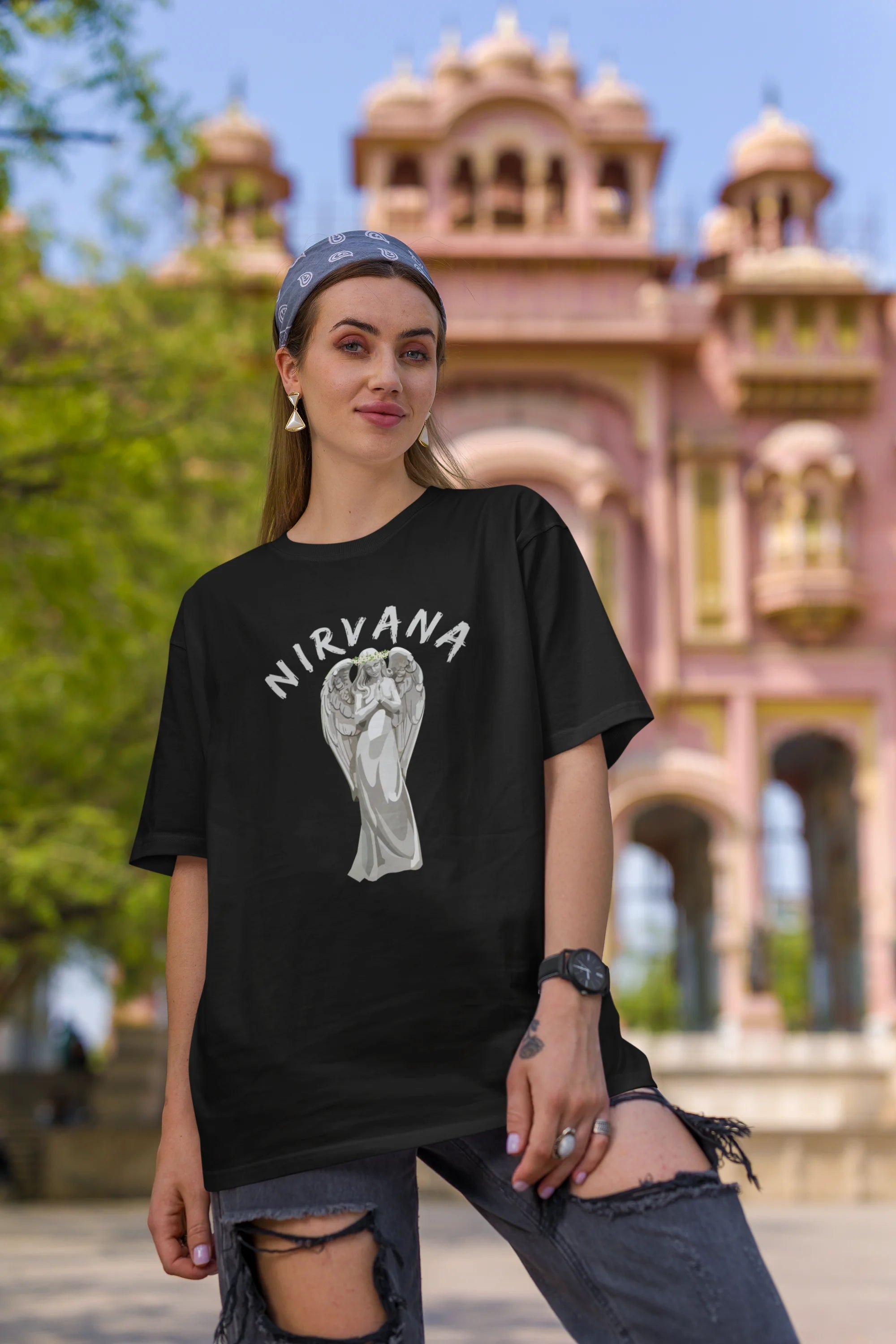 Second front image of female model wearing a black oversized t-shirt featuring a design of a winged angel with the text "Nirvana" above it. Ideal for fans of Nirvana and those who love grunge aesthetics.