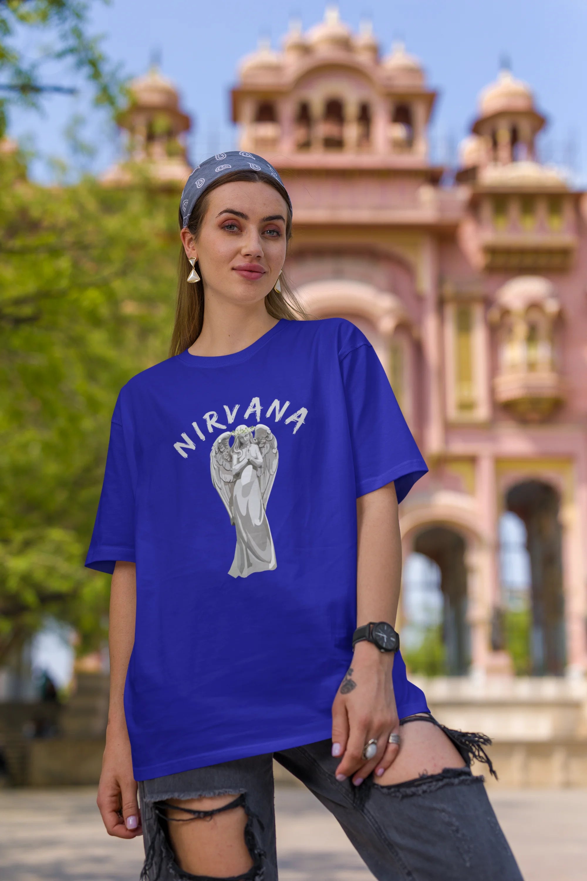 Second front image of female model wearing a\ royal blue oversized t-shirt featuring a design of a winged angel with the text "Nirvana" above it. Ideal for fans of Nirvana and those who love grunge aesthetics.