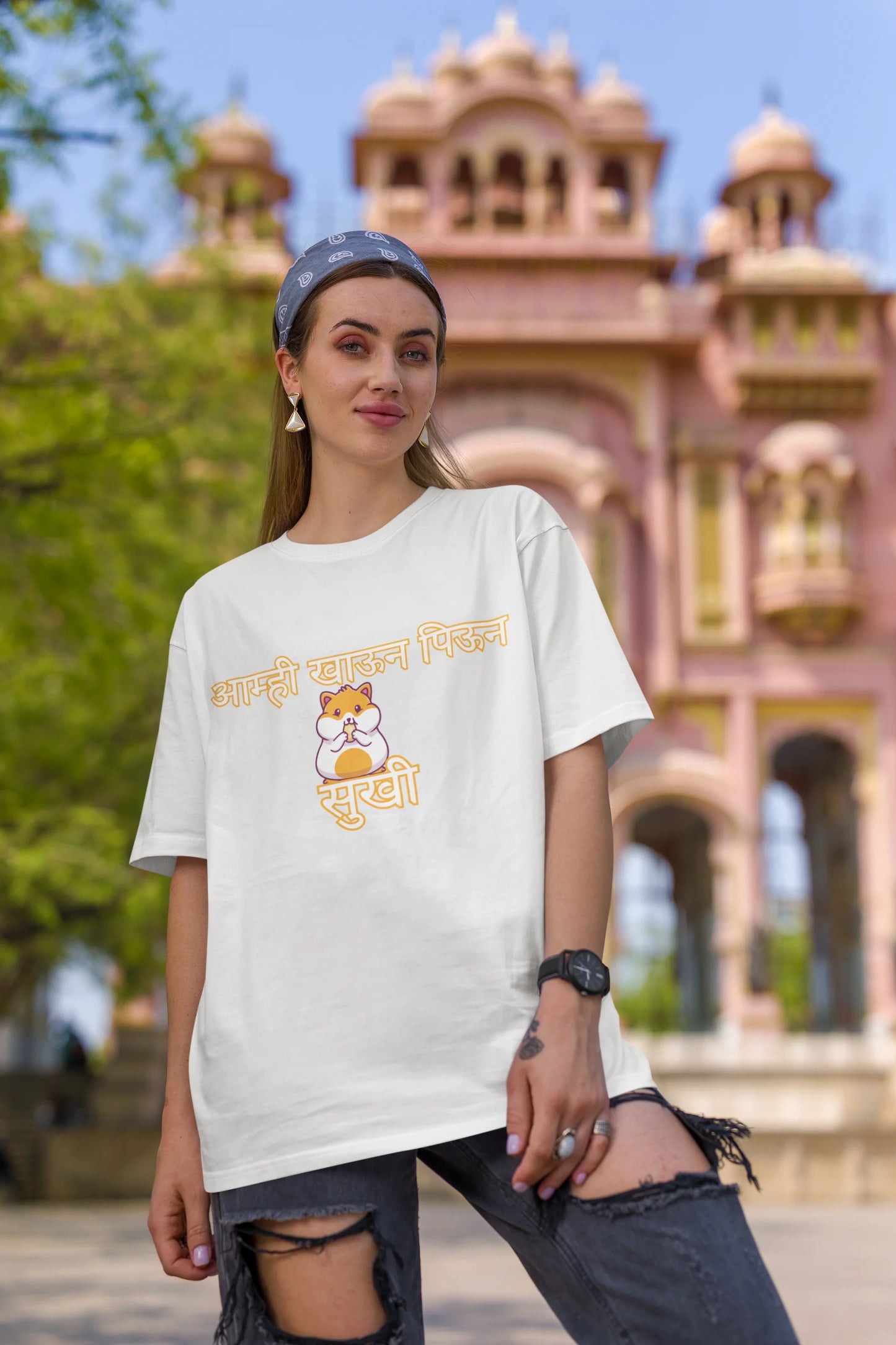 Third front view of female model wearing an off-white oversized t-shirt featuring a design inspired by the Marathi dish "Sukhi," a dry lentil curry. Perfect for fans of Marathi culture, foodies, and anyone who loves a taste of home.