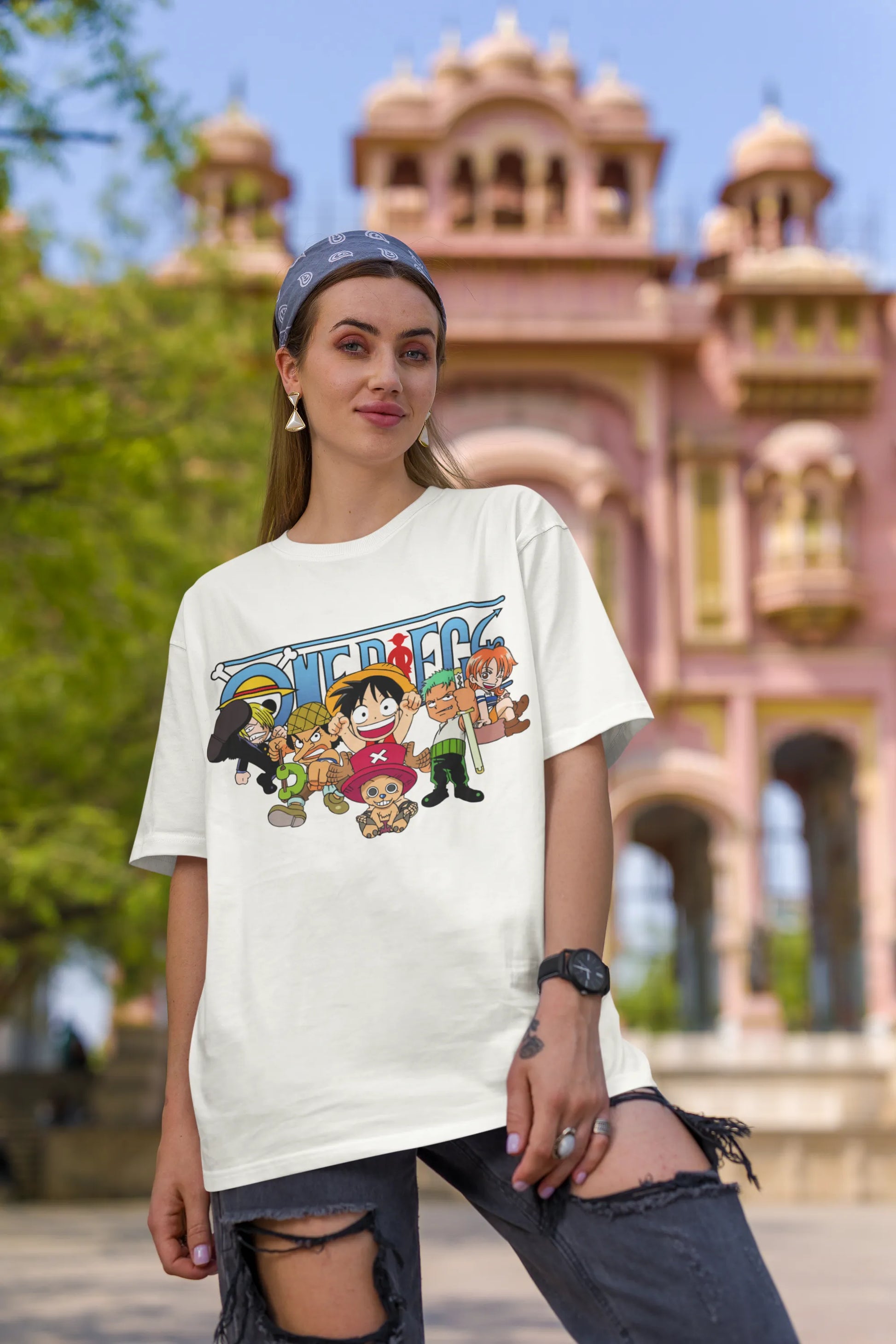 2nd front view of a female model wearing an off-white oversized t-shirt featuring chibi versions of the Straw Hat Crew from the One Piece anime.