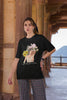 Third front view of female model wearing a black oversized t-shirt with a positive message 