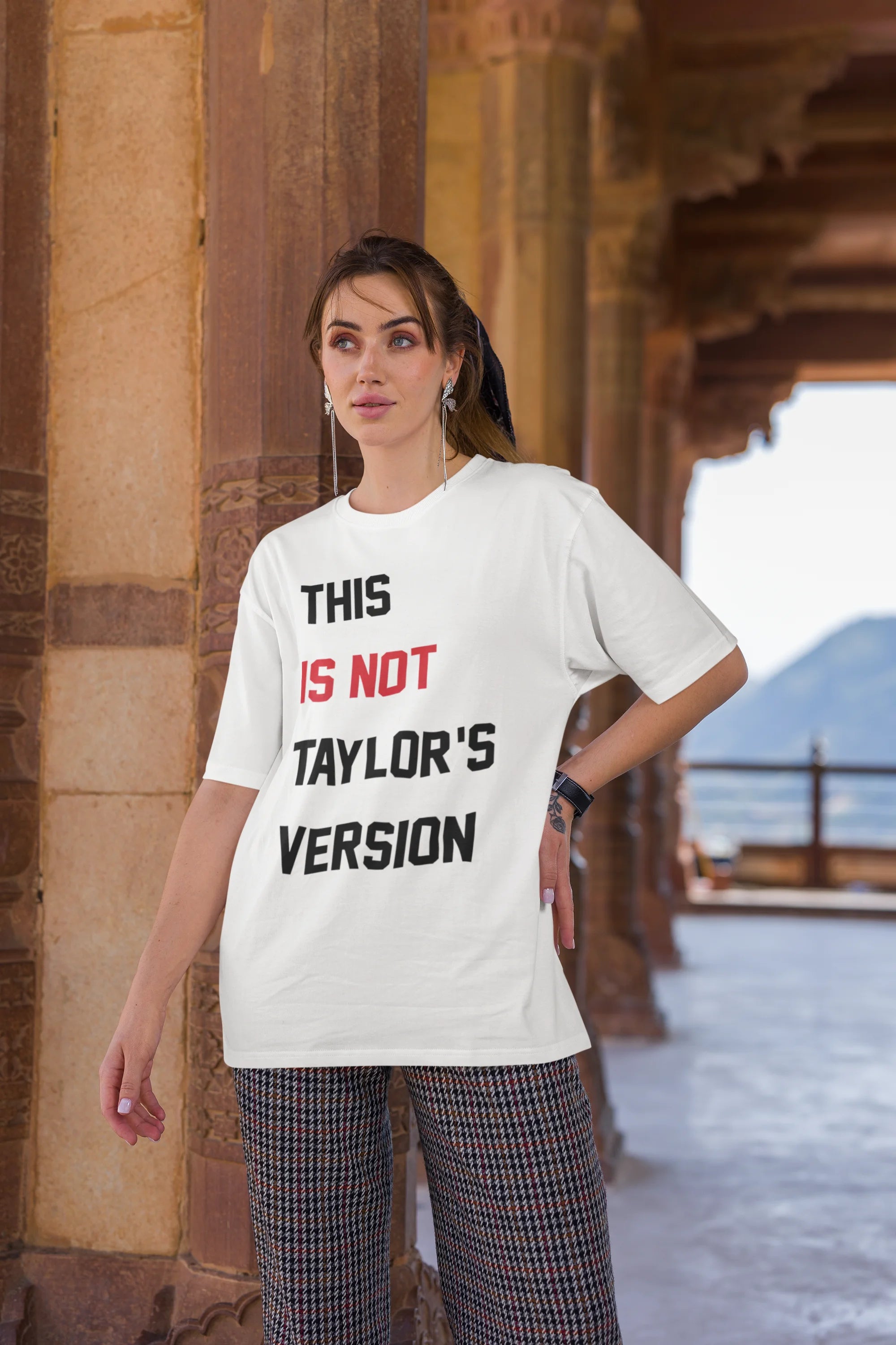 Third image of Woman wearing Taylor Swift Red-themed oversized tee, showcasing iconic eras tour merch and Taylor's Version nod