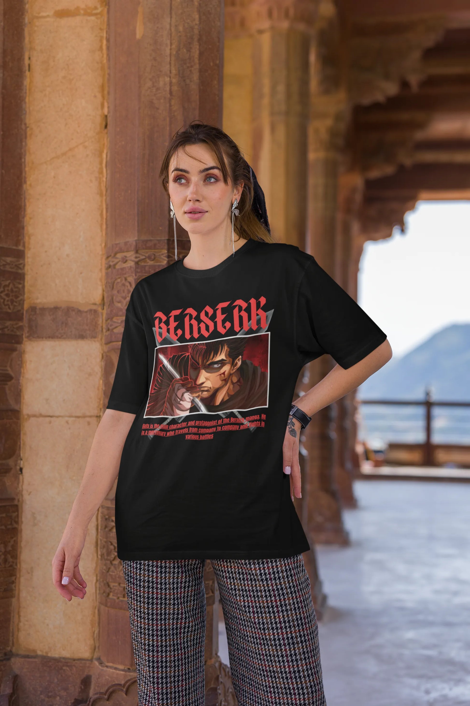 3rd front view of a female model wearing an black oversized t-shirt featuring Guts from the Berserk anime with the text "Berserk" across the design.