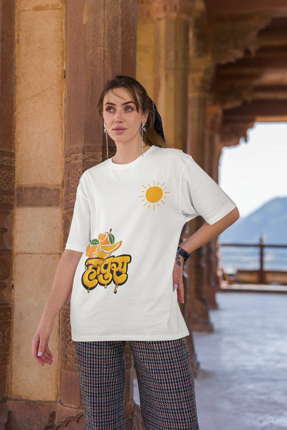 Third front view of female model wearing an off-white oversized t-shirt featuring a design inspired by the Marathi word "Hapus," meaning Alphonso mango. Ideal for fans of Marathi culture, foodies, and anyone who loves the king of fruits.