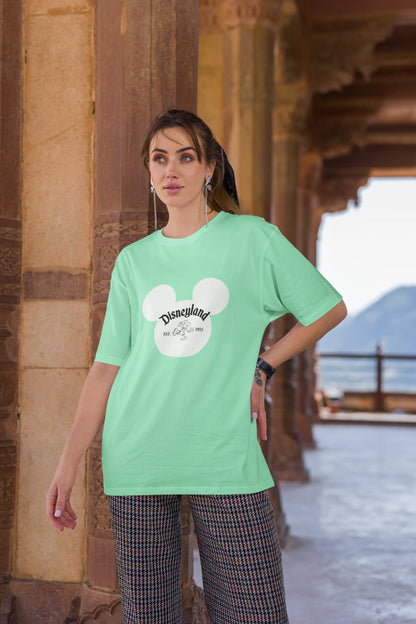 Third image of female model wearing a mint green oversized Disney collection t-shirt featuring a classic Disneyland design.