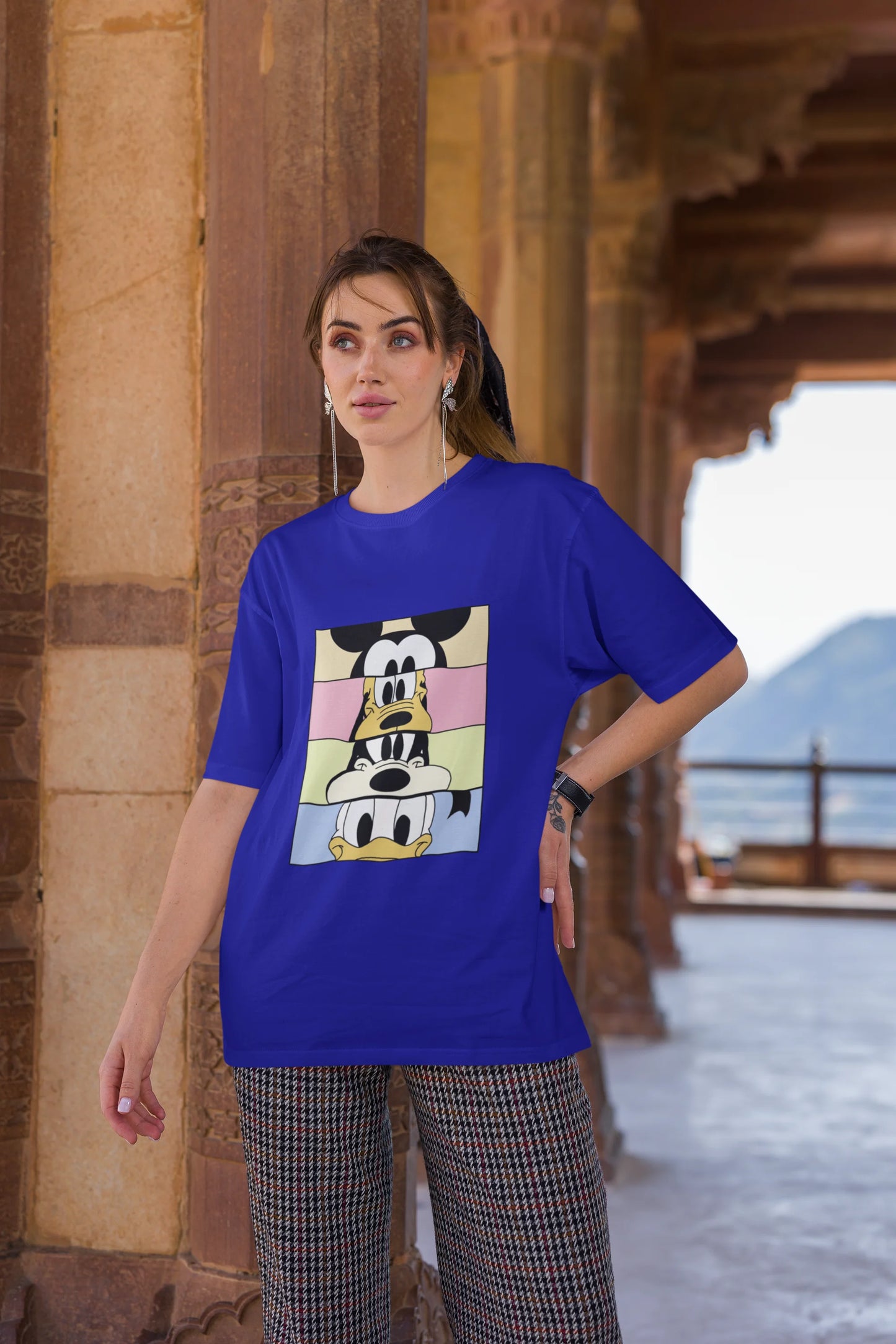 Third image of female Models showcasing blue oversized t-shirt inspired by Mickey Mouse Clubhouse characters: Mickey Mouse, Donald Duck, Goofy, and Minnie Mouse