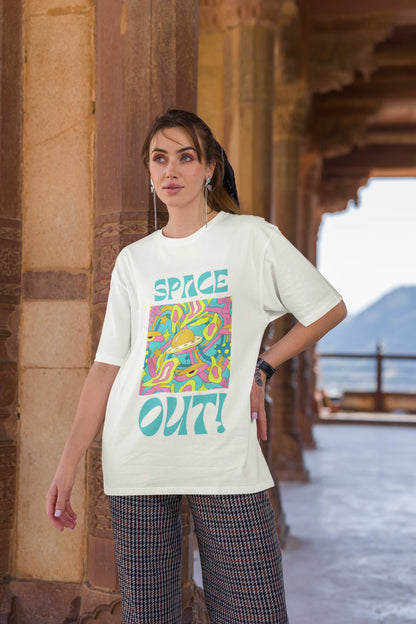 Third image of female model wearing an off white oversized "Spaced Out" t-shirt featuring a vibrant color mashup design that evokes a sense of space exploration, playful aliens, and distant galaxies.