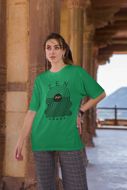 Third front view of a female model wearing an forest green oversized t-shirt featuring an aesthetic design of a setting sun and crashing waves with the text "Zen & Chaos" above it. Ideal for those who love philosophical themes and visually striking clothing.