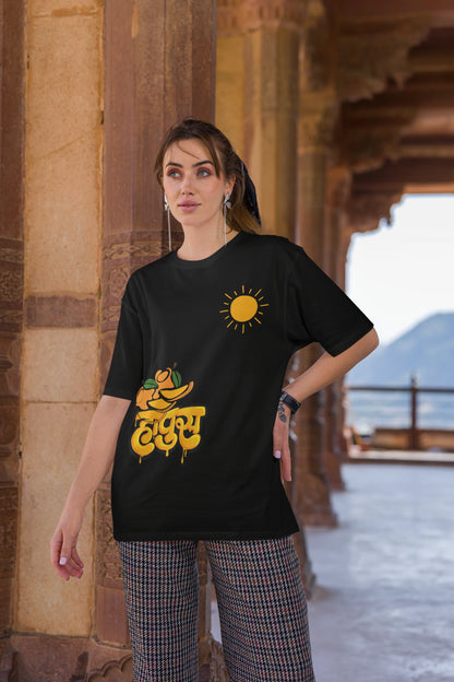 Third front view of female model wearing an black oversized t-shirt featuring a design inspired by the Marathi word "Hapus," meaning Alphonso mango. Ideal for fans of Marathi culture, foodies, and anyone who loves the king of fruits.