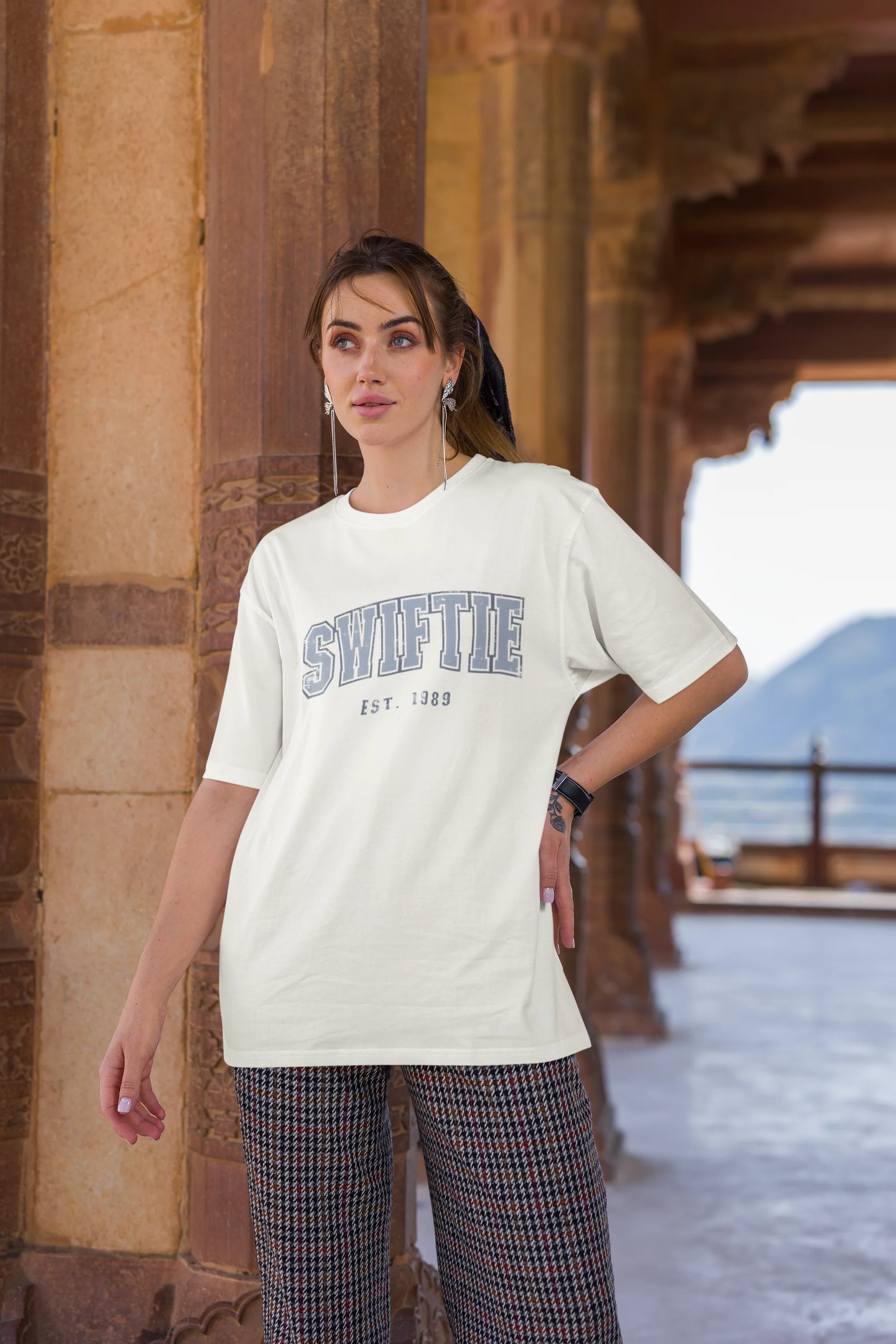 Third image of woman wearing off white Oversize T-shirt featuring Swiftie design, taylor's version